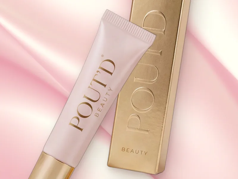 POUT'D Lip Plumper tube and gold box on pink silk, a non-sticky, high-shine lip plumper, $25.
