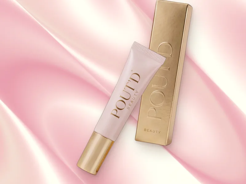 POUT'D Lip Plumper on pink silk: the glossy, glass-shine tube behind the 2026 glazed-lip look, $25